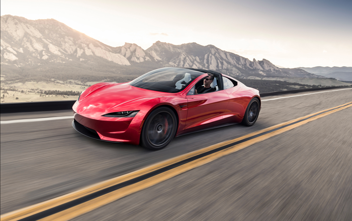 605cf697106eb50019d05b14 | Wagner Certified Collision Red sports car cruising along a two-lane highway with mountains in the background.
