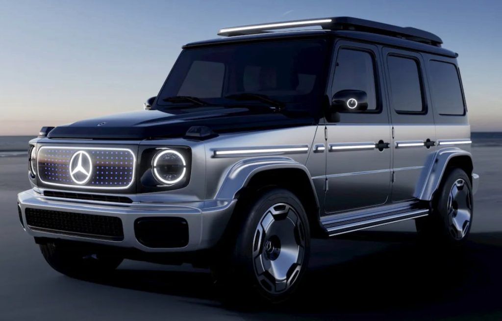 Mercedes-G-Class-Small | Wagner Certified Collision Silver Mercedes-Benz SUV (G-Class) with illuminated grille and side lighting, parked on a dark road at dusk edge of a desert horizon